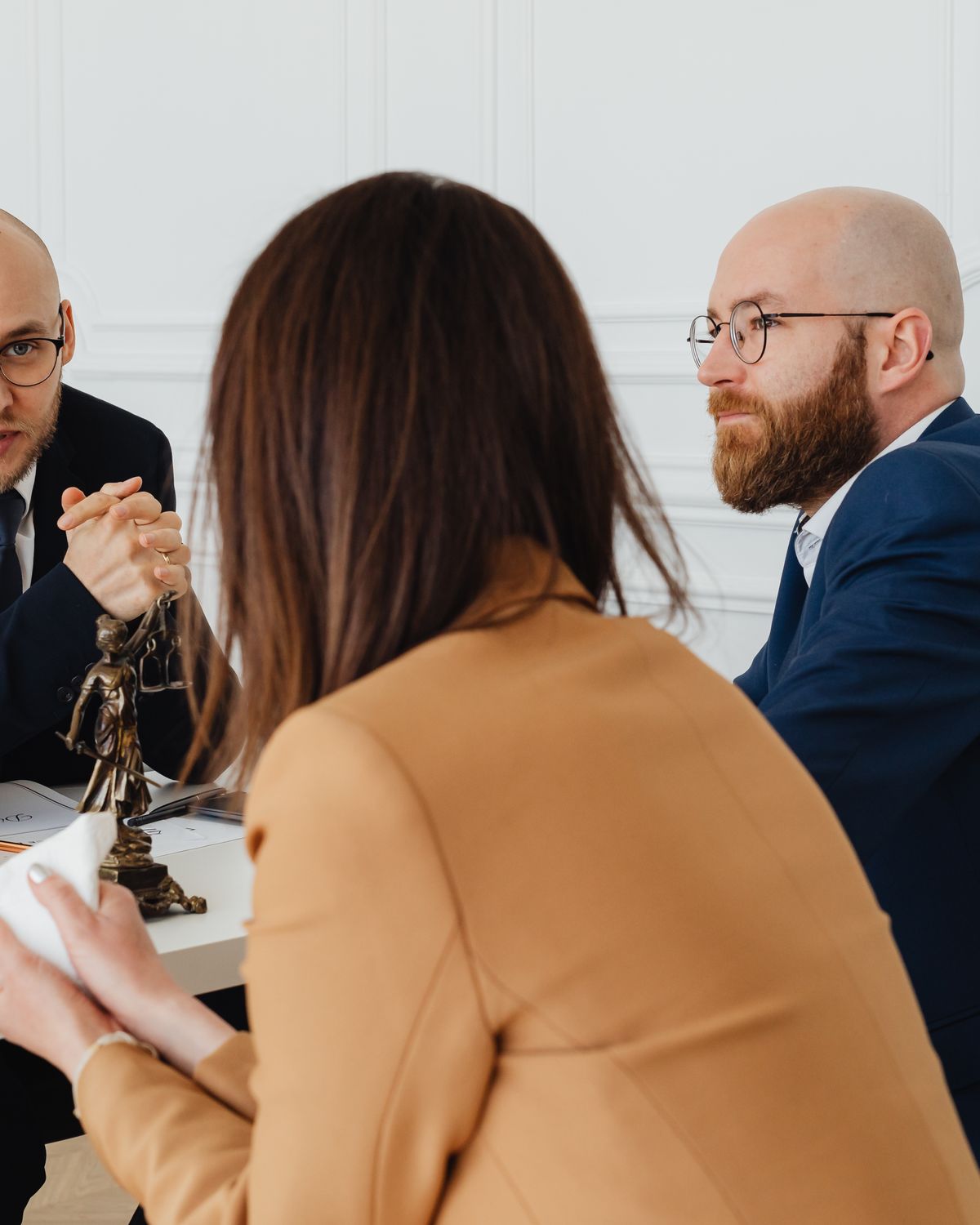 Four people sitting around a table in conversation, papers in front of them.